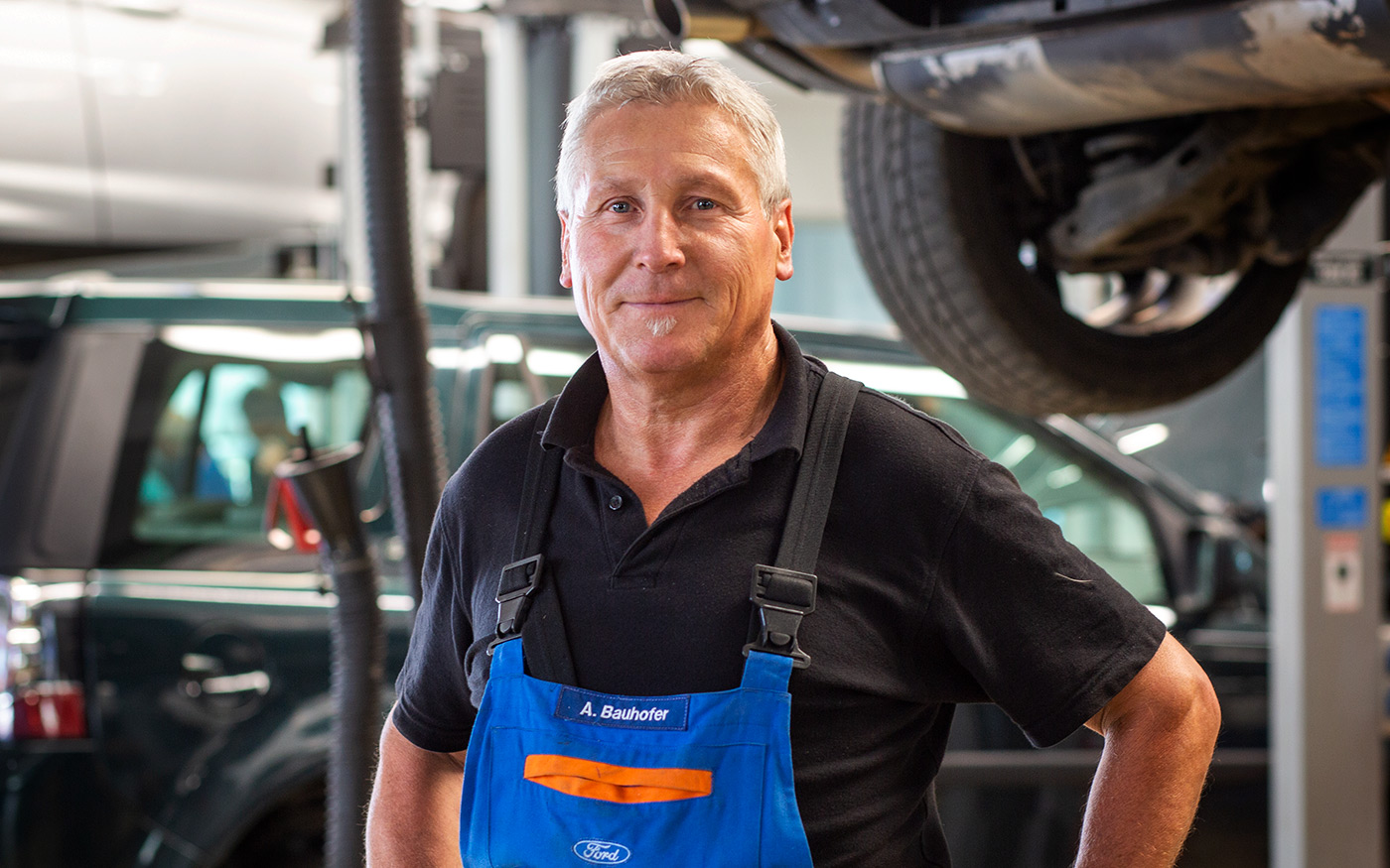 Serviceleiter Achim Bauhofer in blauer Arbeitshose in der Werkstatt des Autohaus Zwerger